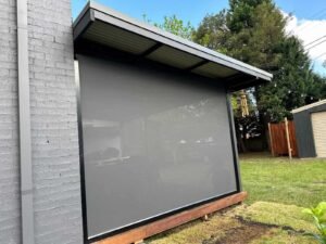 Zip blinds installed on a slanted ceiling for outdoor shade and weather protection