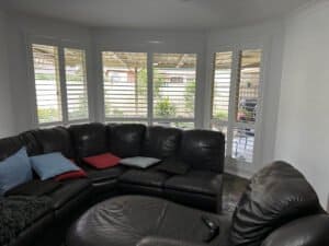 Plantation shutters on bay windows White plantation shutters installed on interior windows for classic light control