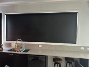 Black vertical blinds on a modern kitchen window for light control and privacy