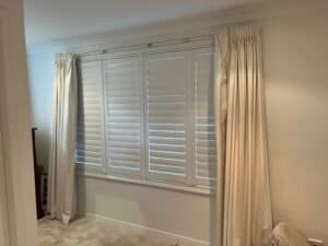 Curtains with Plantation Shutters – Layered Light Control Curtains layered over white plantation shutters for added softness and style