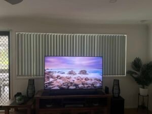 Vertical blinds installed on a large window in a Central Coast TV room, providing light control and privacy
