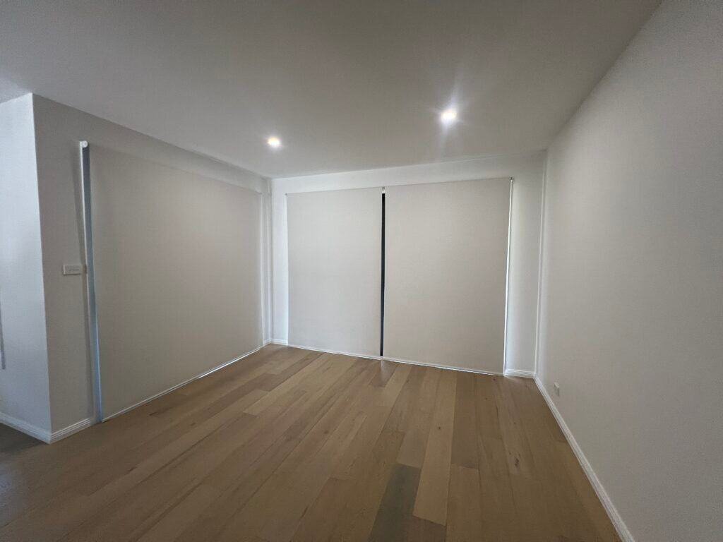 Custom roller blinds fitted over large sliding glass doors in a modern Central Coast home