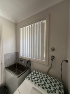 Vertical blinds for laundry room window offering privacy and easy light control