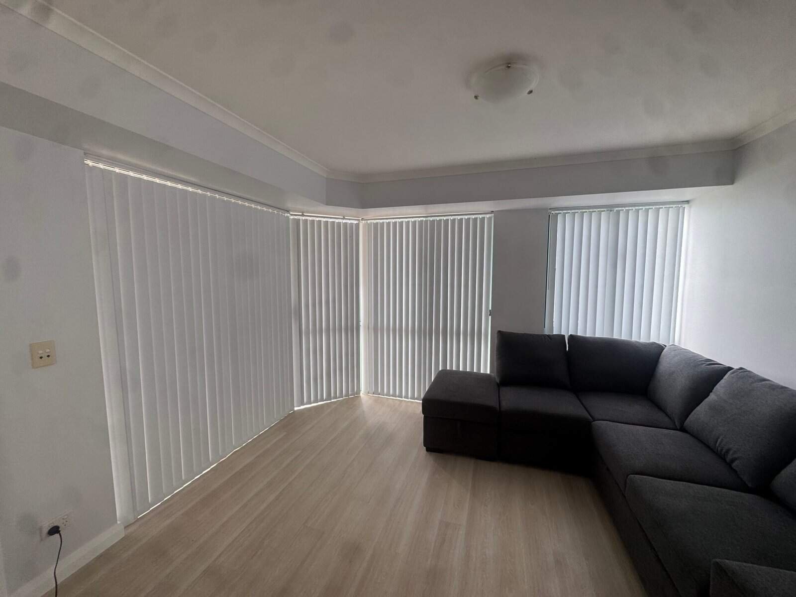 Vertical Blinds on Bay Windows – Central Coast Vertical blinds installed on modern bay windows in a living room