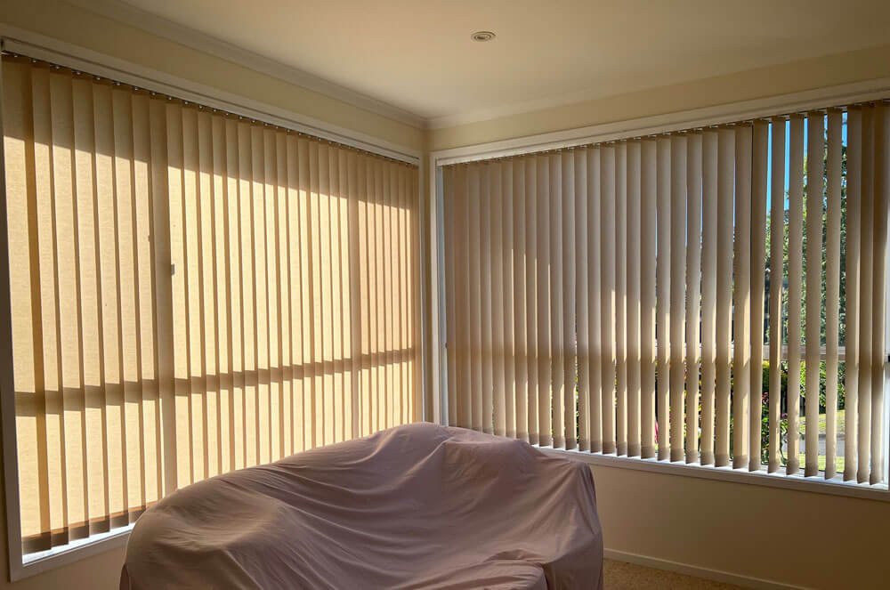 Can I get blockout or light-filtering vertical blinds showing a bright living room with modern vertical blinds half open to filter light.