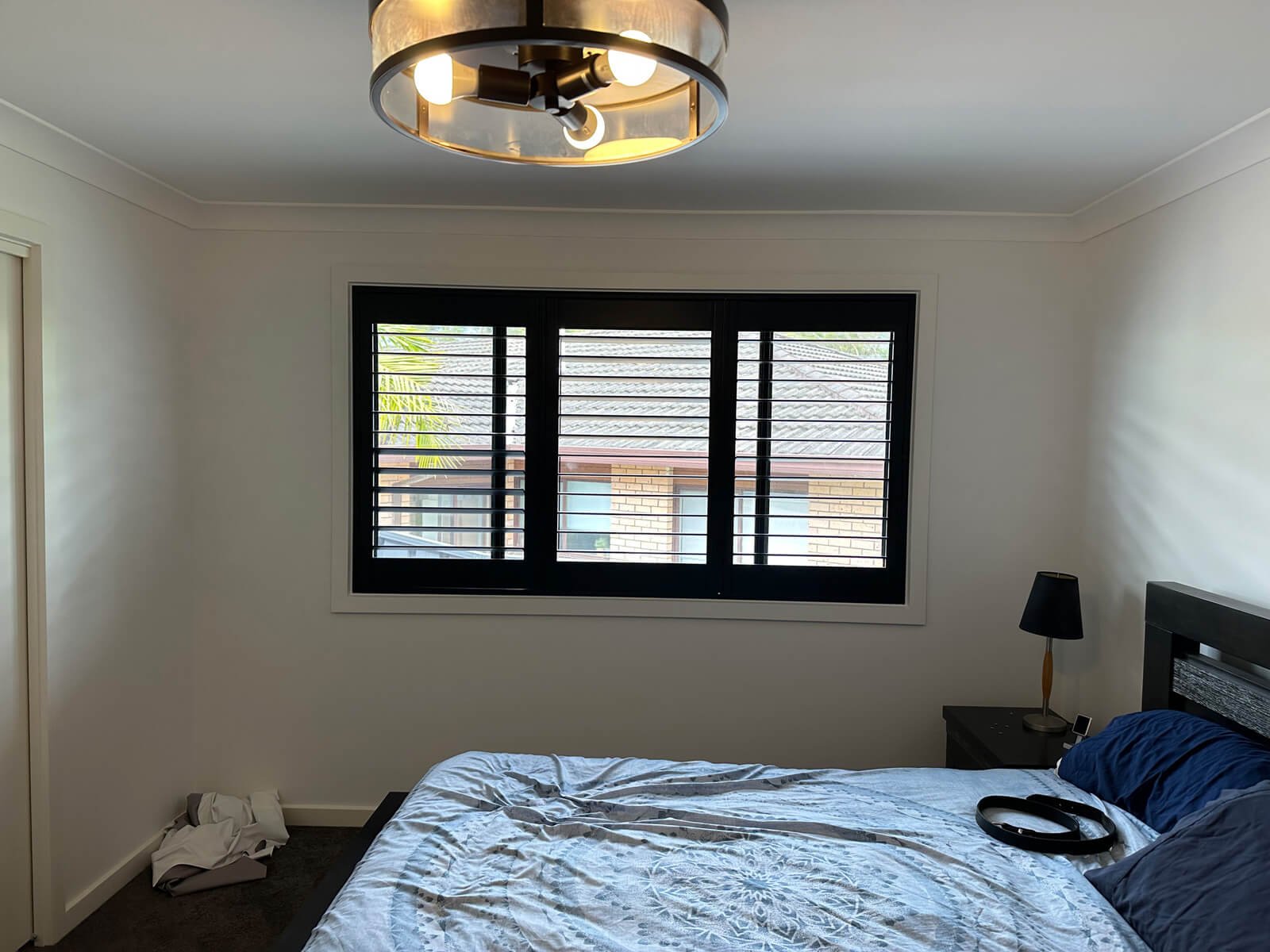 are-pvc-shutters-better-than-wood Black timber plantation shutters in a modern living room – are-pvc-shutters-better-than-wood comparison example.