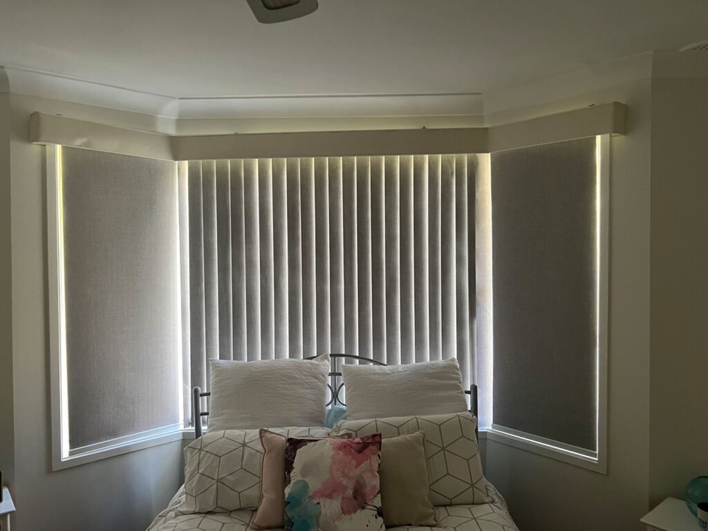 Side-by-side comparison of vertical blinds and roller blinds in a modern home – Vertical Blinds vs Roller Blinds example.