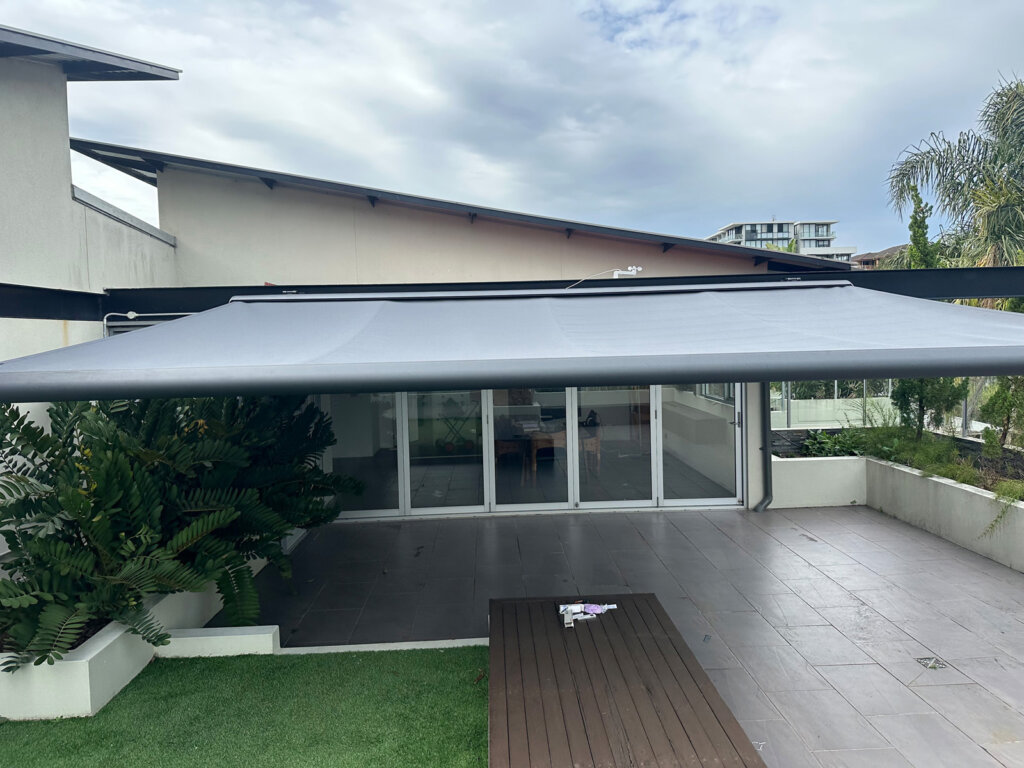Modern outdoor awning providing shade over a patio area and reducing indoor heat