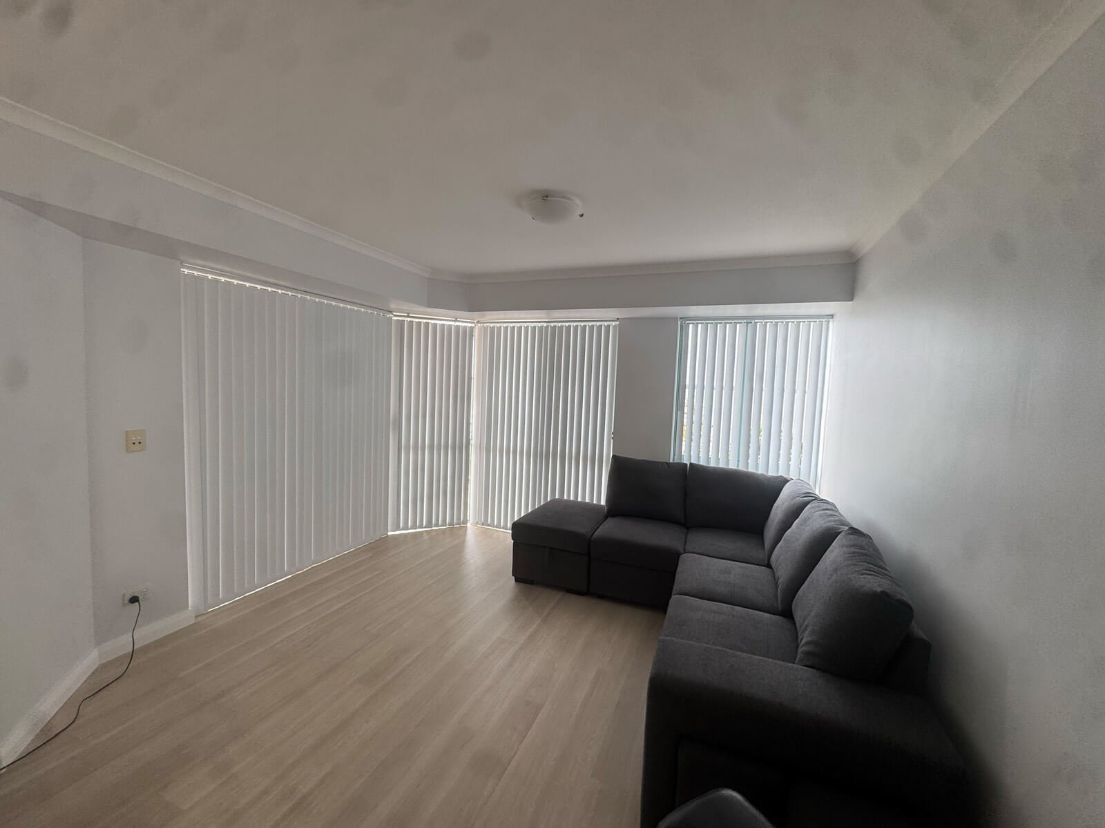 Vertical Blinds for Tall Bay Windows – Floor-to-Ceiling Privacy Solution Vertical blinds on tall bay windows in a bright open-plan room