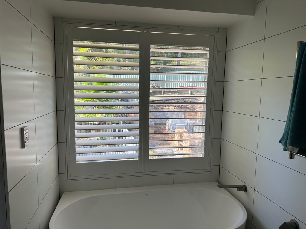 White waterproof plantation shutters installed in a modern Central Coast bathroom providing privacy and ventilation