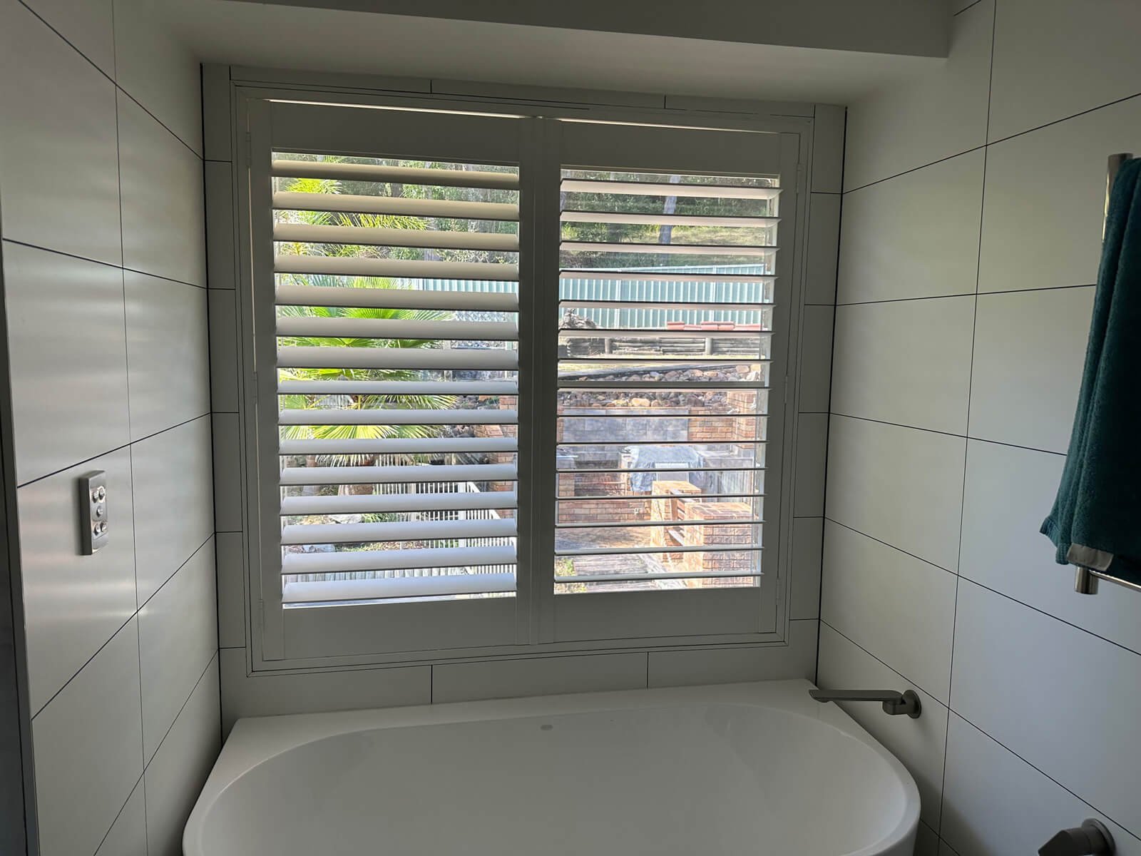 White waterproof plantation shutters installed in a modern Central Coast bathroom providing privacy and ventilation