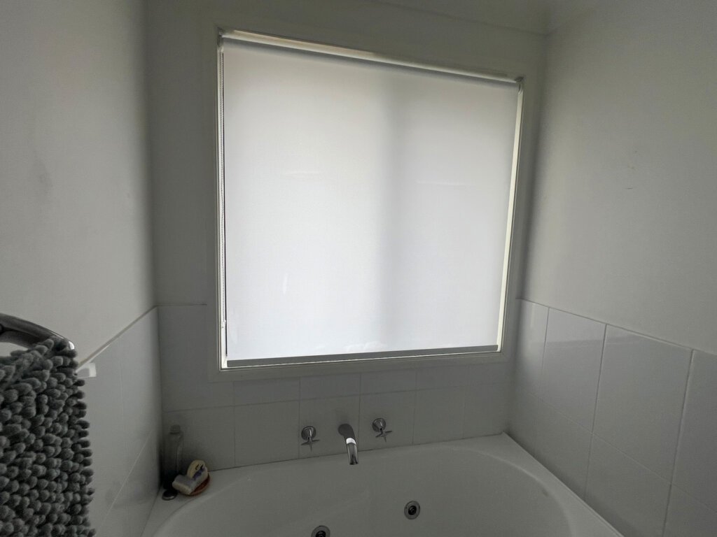 Moisture-resistant roller blinds installed in a modern Central Coast bathroom, providing privacy and waterproof protection.