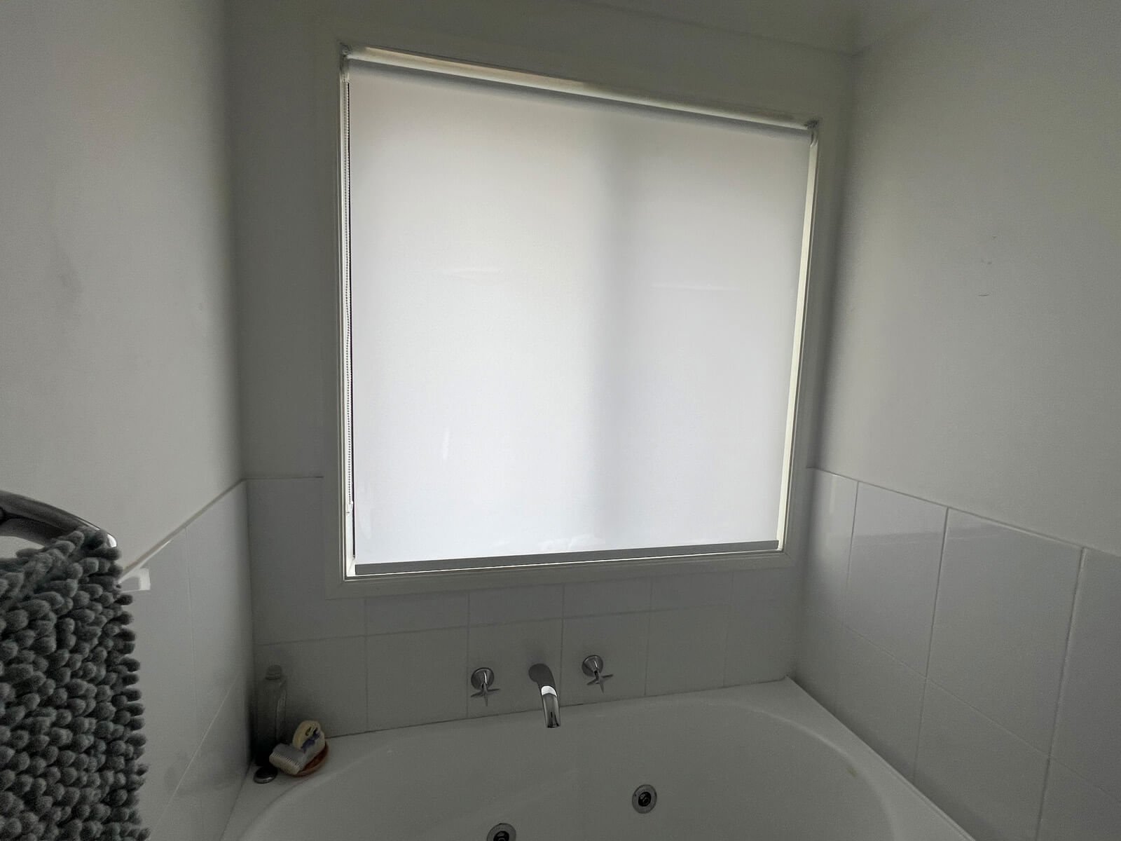 roller blinds in bathroom central coast Moisture-resistant roller blinds installed in a modern Central Coast bathroom, providing privacy and waterproof protection.