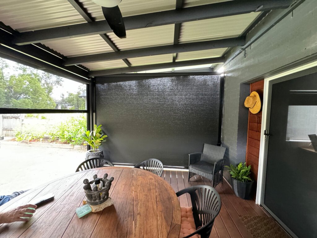 Modern coastal patio with outdoor blinds providing shade and wind protection – Best Outdoor Blinds for Patios and Coastal Living Spaces.