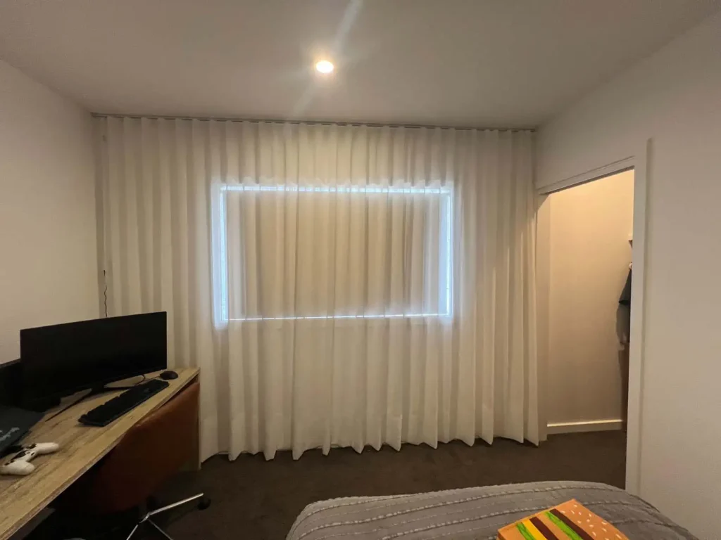 Sheer curtains in a bedroom showing how curtains diffuse light into a soft glow.