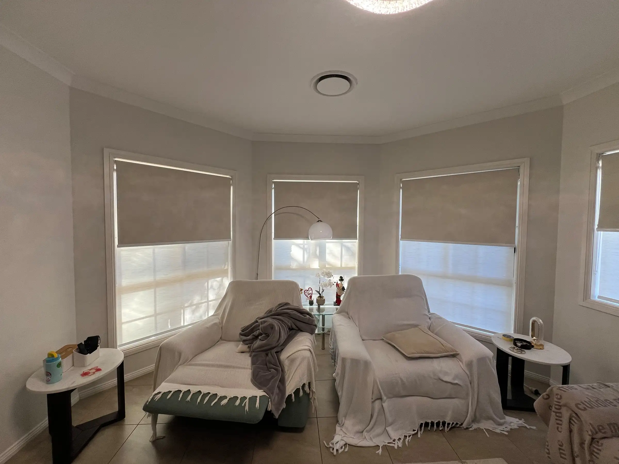 Double roller blinds installed in a Central Coast living room showing sheer and blockout layers for privacy and light control.
