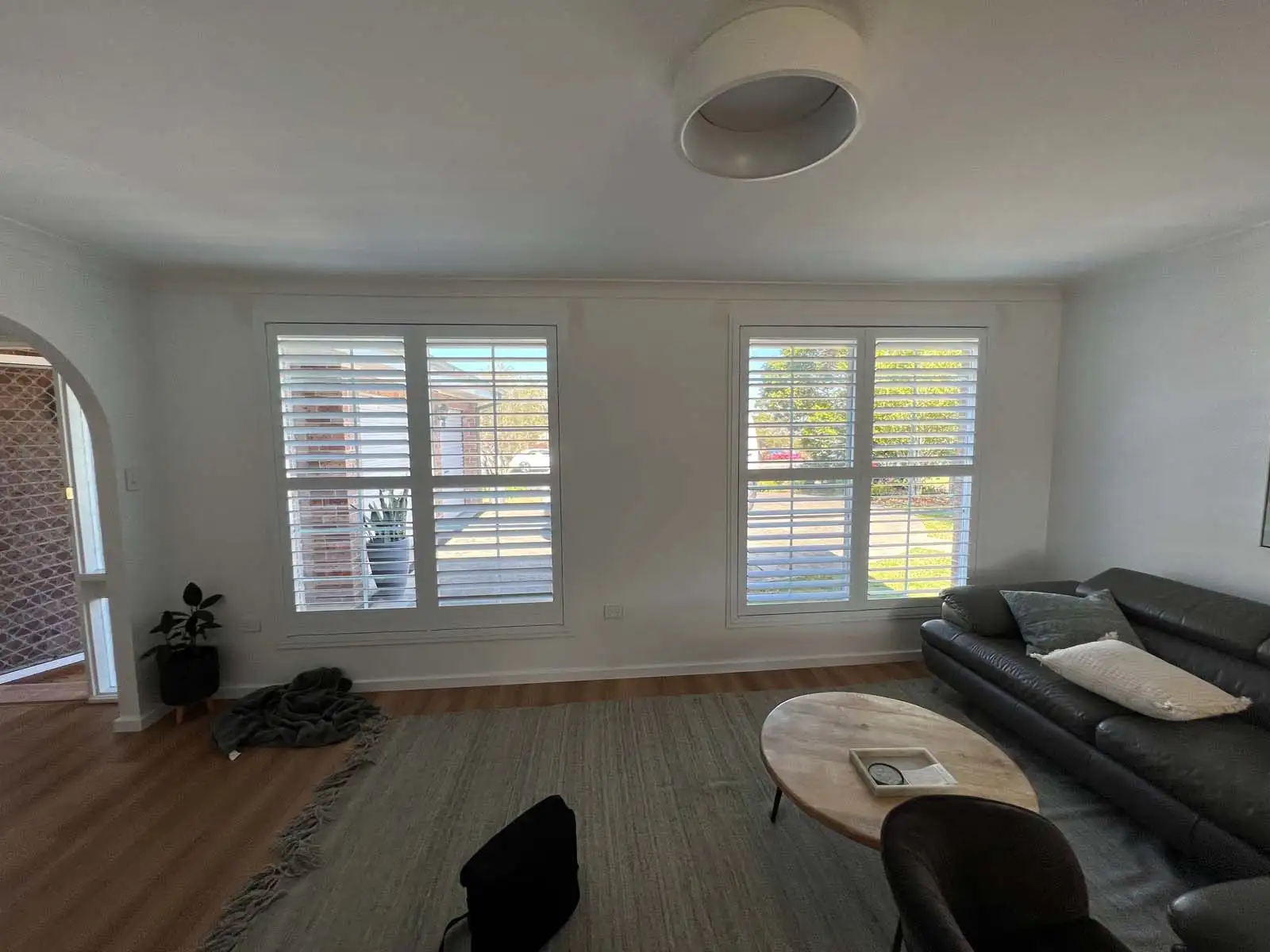 Custom white plantation shutters installed in a Central Coast living room with natural light