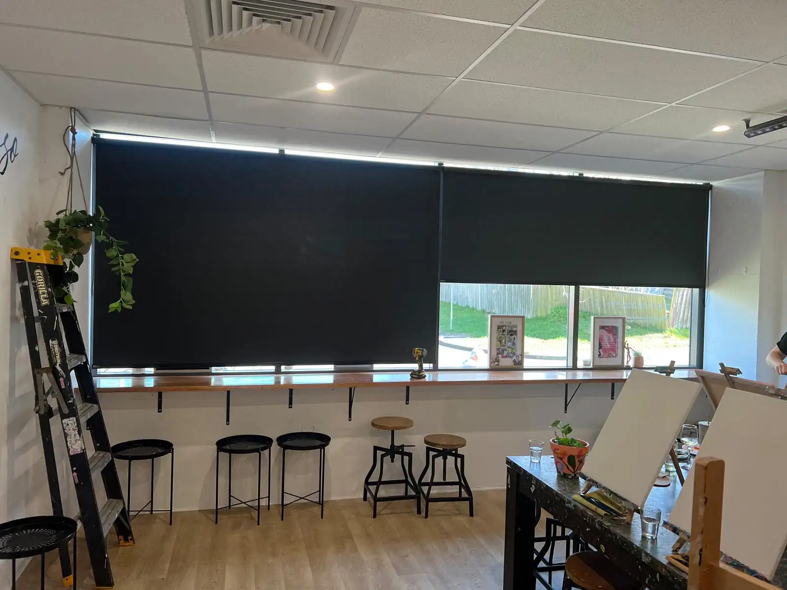 Stylish black blockout roller blinds in a Central Coast studio providing total light block and privacy