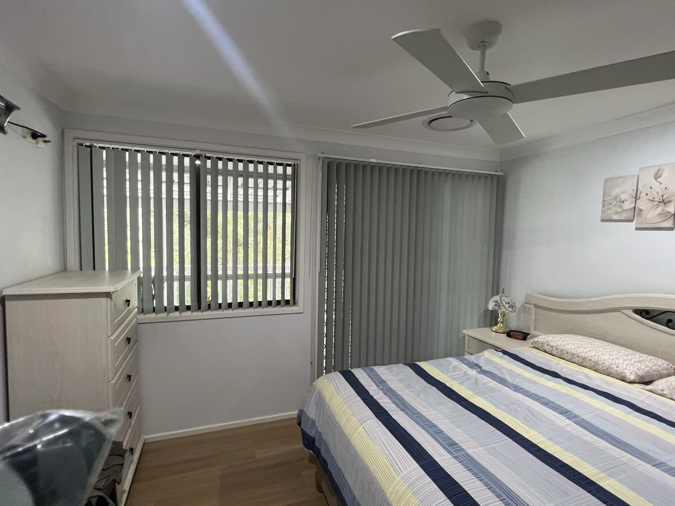 Vertical Blinds for Bedrooms – The Blind Crew Soft light filtering through custom vertical blinds in a Central Coast bedroom – installed by The Blind Crew.