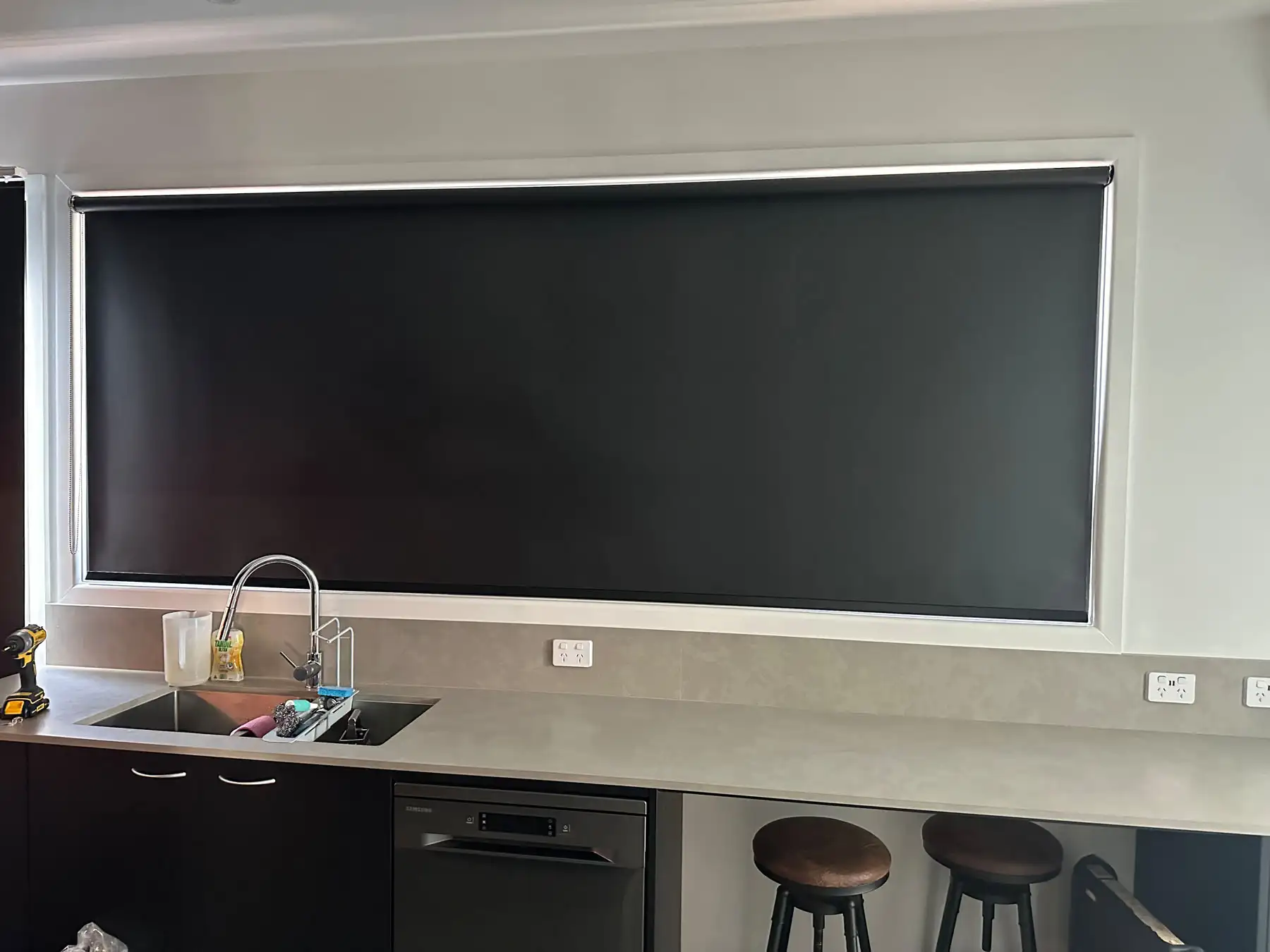 Roller blinds used as kitchen blinds in a wide kitchen view, providing light and heat control