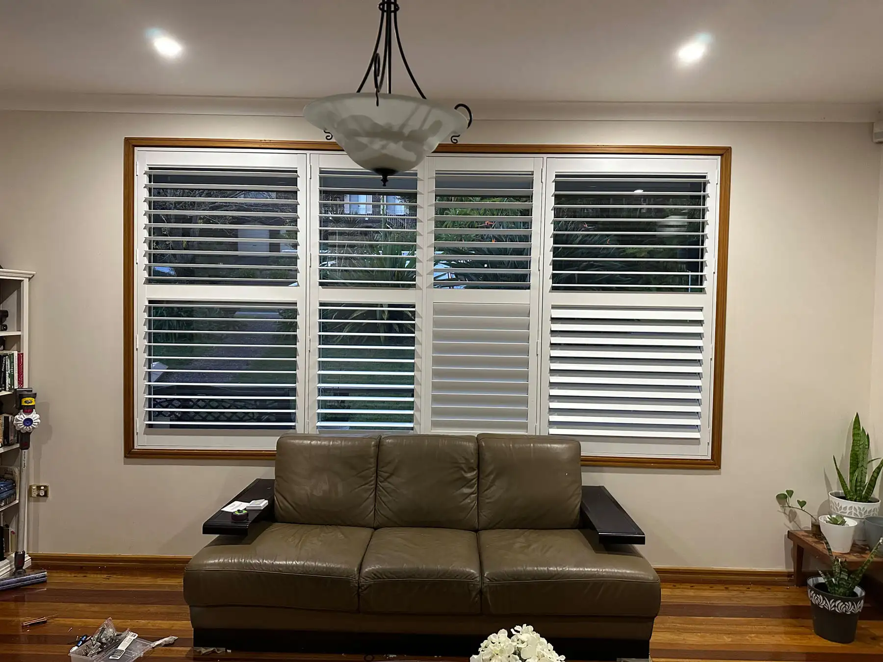 Plantation shutters used as lounge room blinds in a wide lounge room view, providing light control and privacy