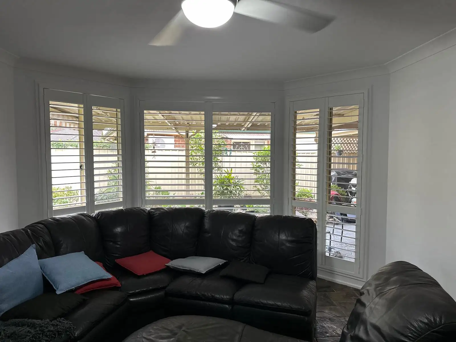 Plantation shutters installed as blinds for bay windows in a wide bay window view, providing precise light control