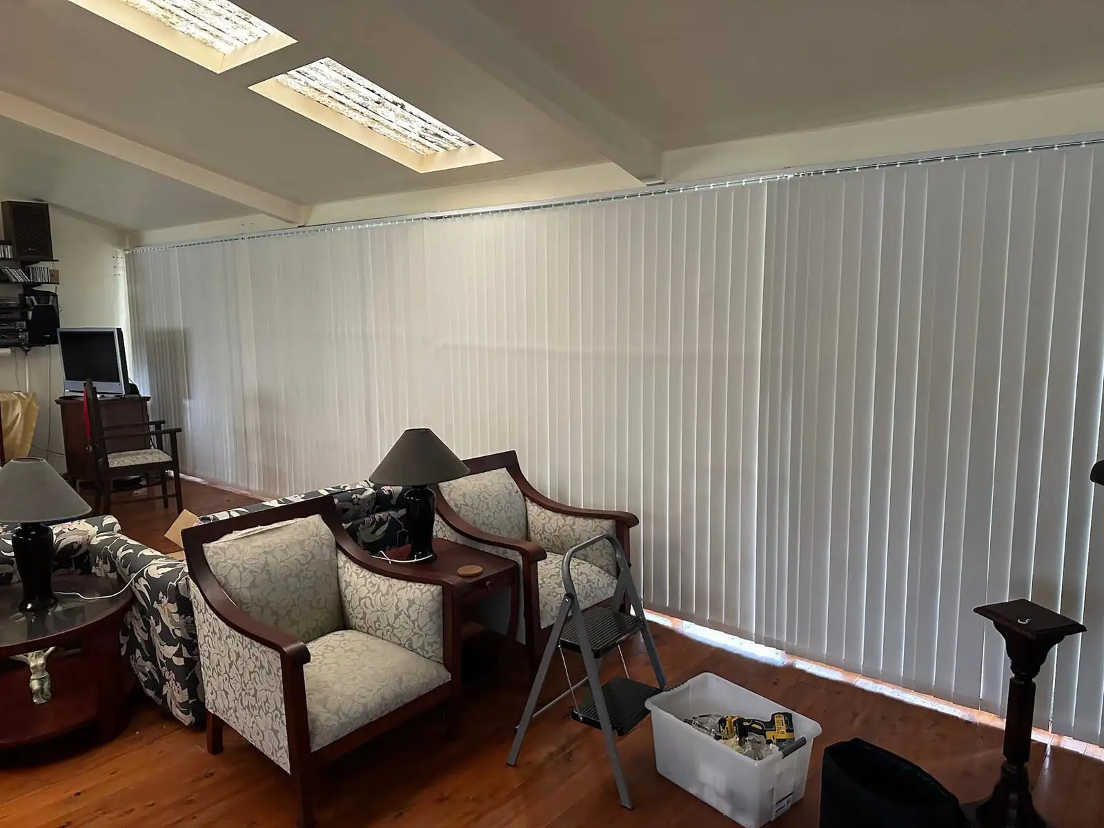 Vertical blinds installed as blinds for large windows in a wide interior view, providing adjustable light control